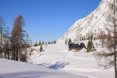 Tauplitz, Avusturya - 02 Şubat 2023: Dağlarda kar altında geleneksel bir Avusturalya evi