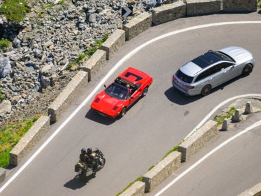 Stelvio Geçidi, İtalya - 15 Temmuz 2023: Güneşli bir yaz gününde Stelvio Geçidi, kırmızı spor araba