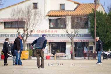 Saintes Maries de la Mer, Fransa - 9 Mart 2023: Güneşli bir kış gününde, Place des Gitans 'ta insanlar Petanque oynuyor