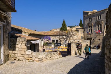 Les Baux-de-Provence, Fransa - 4 Mart 2023: Baharın güneşli bir gününde Les Baux de Provence caddesi