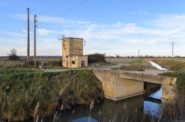 Arles, Fransa - 23 Mart 2023: Güneşli bir kış akşamında Arles yakınlarındaki eski trafo istasyonu, mavi gökyüzü