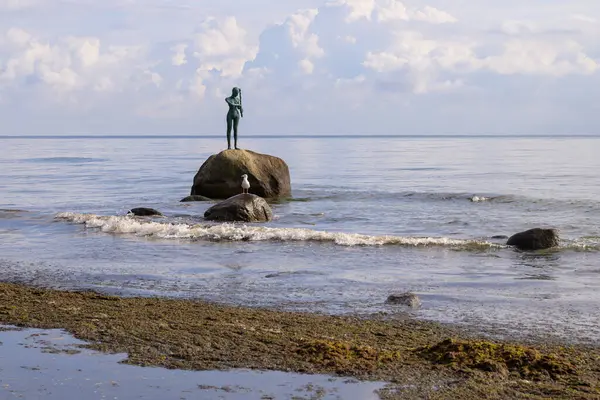 Satış, Almanya - 1 Temmuz 2024: Bulutlu bir günde bir kayanın üzerinde duran bir kızın heykeli