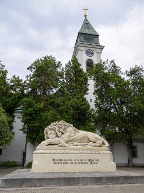 Viyana, Avusturya - 8 Eylül 2022: 1858 'de Anton Dominik von Fernkorn tarafından yaratılan ve ölen bir aslan olan Aziz Martin' e adanmış kilisenin önünde 21 Eylül 'de Aspern Savaşı' nda ölen Avusturyalı askerlerin anısına süslenmemiş bir kaideye dayanmaktadır.