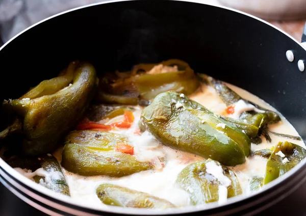 Geleneksel ev yapımı dolma biber. Pişirme kabında peynir ve krema sosuyla doldurulmuş. Latin yemeği.