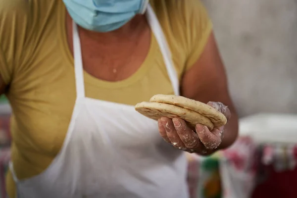 Elinde mısır tortillası olan bir kadın servis edilmeye hazır.