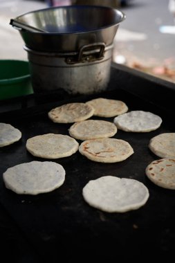 Sıcak bir ızgarada yaşlı bir kadın tarafından yapılan mısır ekmeği.