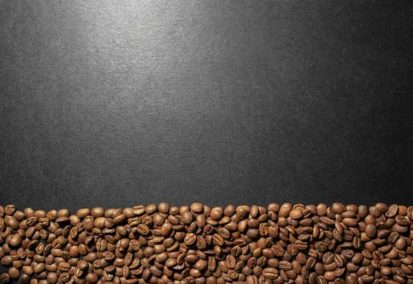 Pieczone Ziarna Kawy Leżą Dole Ramki Czarnej Powierzchni Odbiciami Światła — Zdjęcie stockowe