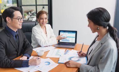 Asyalı iş adamları toplantısı. Ofisteki bilgisayar ekranındaki grafiklere, indekslere ve numaralara bakan borsacılar.