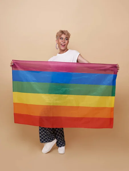 ヌードカラーの背景に隔離された虹の旗を示す若いアジア系トランスジェンダーLgbt ジェンダーの表現の誇りと平等の概念 — ストック写真