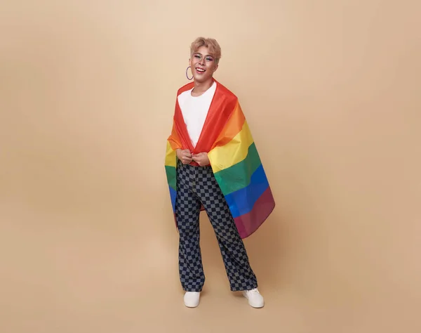 ヌードカラーを背景に孤立した肩の上にレインボーフラッグを持つ若いアジア系トランスジェンダーLgbt ジェンダーの表現の誇りと平等の概念 — ストック写真