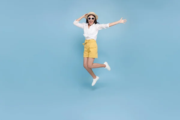 青いスタジオの背景に隔離された夏の時間に飛び込む幸せな笑顔の若いアジアの観光客の女性 コピースペース — ストック写真
