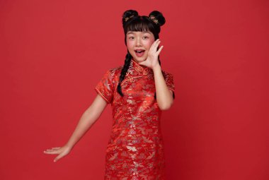 Geleneksel Cheongsam Qipao elbisesi giyen mutlu Asyalı çocuk Çin 'in 2024 yılının kırmızı arka planda izole olduğunu duyur..