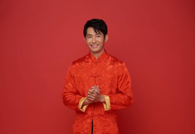 Mutlu Çin yılbaşı 2024 portresi Asyalı mutlu gülümseme kırmızı arka planda izole edilmiş geleneksel kırmızı elbiseler giyiyor..