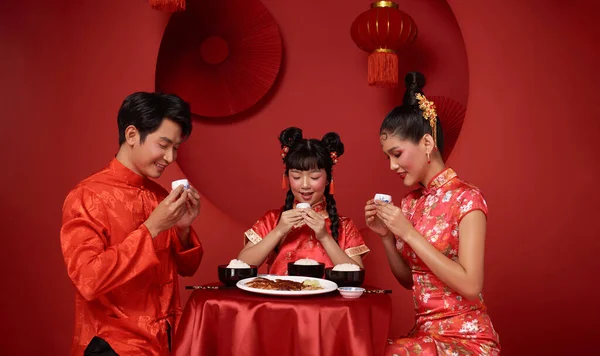 Happy Chinese new year 2024. Asian family dinner food and drinking tea for prosperity celebration festival isolated on red decoration traditional festival background.