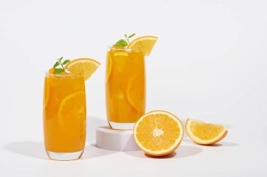 Beyaz arka planda portakal dilimi ile süslenmiş sıkılmış portakal suyu..