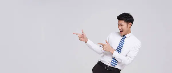 Glücklich Lächelnde Junge Hübsche Asiatische Geschäftsmann Zeigt Weg Und Sieht lizenzfreie Stockbilder