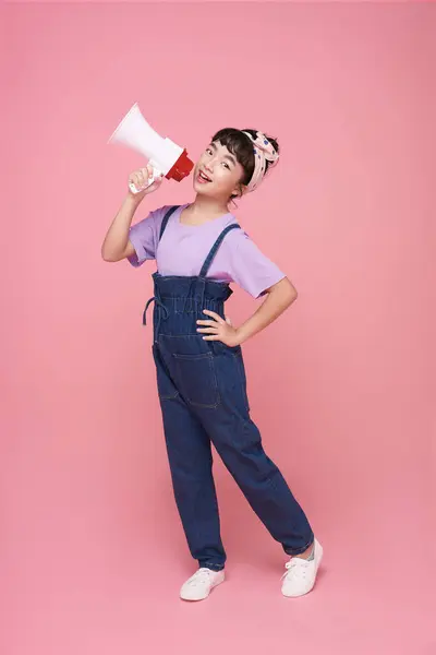 Asiatique Petite Fille Debout Tenant Mégaphone Isolé Sur Fond Rose Image En Vente
