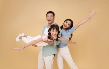 Mutlu gülümseyen Asyalı aile eğlencesi çıplak arka planda birlikte seyahat etmeye hazır..