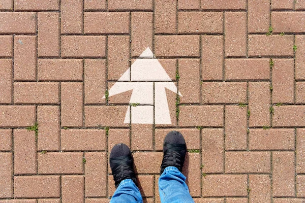 Selfie of feet and arrows on the road. top view. Businessmen in black shoes standing on a road with many white arrow pathway sign choices. Future life with different direction symbol. business success