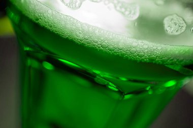 A glass of green beer is a symbol of St. Patrick's Day, close-up, macro