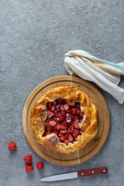Masanın üzerine çilekli turta yakın plan. Çilekli turta açıldı..