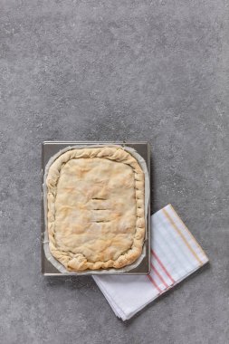 Homemade pie with meat or vegetable filling on a metal tray, copy space, top view, homemade pastries