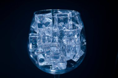 Alkolik votka, tekila ve tonik karışımı, buzlu, limonlu ve naneli, koyu bir arka plan, makro, yakın plan.