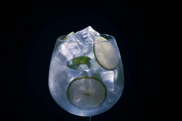 伏特加或龙舌兰酒和滋补品的酒精混合物 深色背景下的冰 石灰和薄荷 宏观特写 — 图库照片