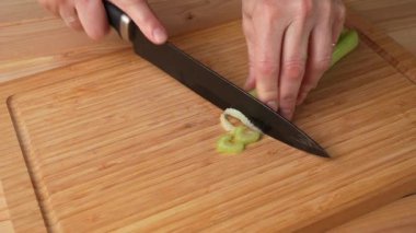 Kereviz sağlıklı gıda ürünü, bir kadın mutfak tahtasına kereviz sapı kesiyor, yakın plan, ev yemeği. 