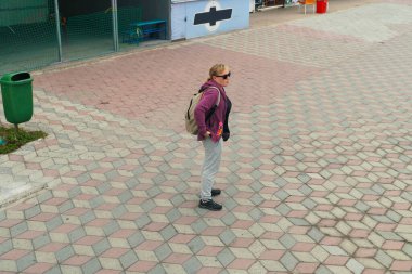 Sırt çantalı genç bir turist kaldırımda durur ve nereye gideceğini seçer..