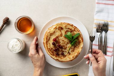 Hafif taşlı arka planda büyük gözlemeler bayan aşçı tarafından sunulur, üst manzara, ev yemekleri, Maslenitsa, Paskalya