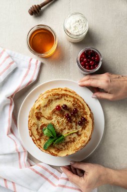Hafif taşlı arka planda büyük gözlemeler bayan aşçı tarafından sunulur, üst manzara, ev yemekleri, Maslenitsa, Paskalya