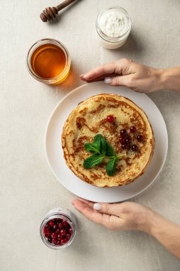 Hafif taşlı arka planda büyük gözlemeler bayan aşçı tarafından sunulur, üst manzara, ev yemekleri, Maslenitsa, Paskalya
