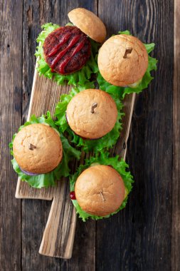 Lezzetli ızgara ev yapımı sığır eti, domates, peynir, salatalık ve marullu hamburger.