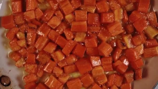 フライパンクローズアップの明るいオレンジキャロット 電気ストーブのライフスタイルのビデオで家庭のキッチンで料理 — ストック動画