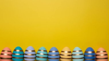 Sarı zemin üzerinde paskalya yumurtaları metin, üst görünüm, düz yatış için kopyalama alanı ile