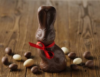 Paskalya çikolatalı tavşan ve çikolatalı yumurtalar ahşap antika masa üzerinde, reklam için kopyalama alanı.