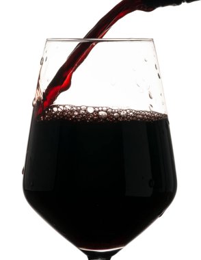 Şarap kadehine kırmızı şarap dökülüyor. Beyaz arkaplanda donmuş sıvı hareketi