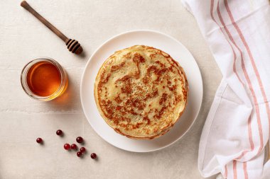 Krepler, beyaz tabakta bal olan ince krepler. Mermer arka plan. Üstte görüntü.