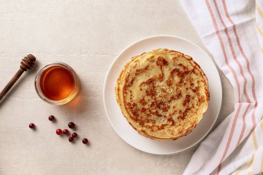 Krepler, beyaz tabakta bal olan ince krepler. Mermer arka plan. Üstte görüntü.