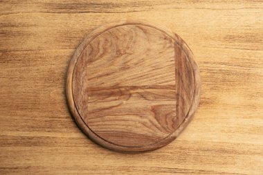 Boş yuvarlak pizza tahtası ahşap arka planda, üst manzara