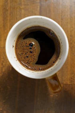 Kahve fincanının üst görüntüsü ahşap masada, kapat.