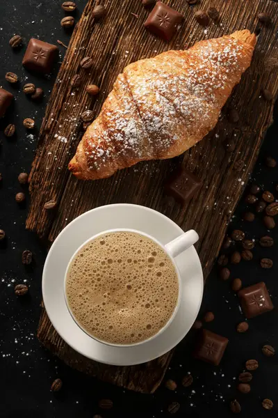 Kahve dükkanı konsepti. Büyük bir bardak cappuccino ve çikolatalı kruvasan.