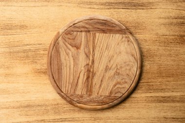 Kırsal ahşap eğri bir pizza tahtası eski ahşap bir arka plana yerleştirilmiş, pizzacı kavramları ve yemek sunumları için mükemmel..