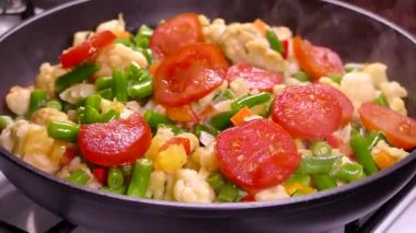 Donmuş sebzelerden sebze güveci pişiriyorum. Domates, kuşkonmaz ve lahana tavada pişiyor..