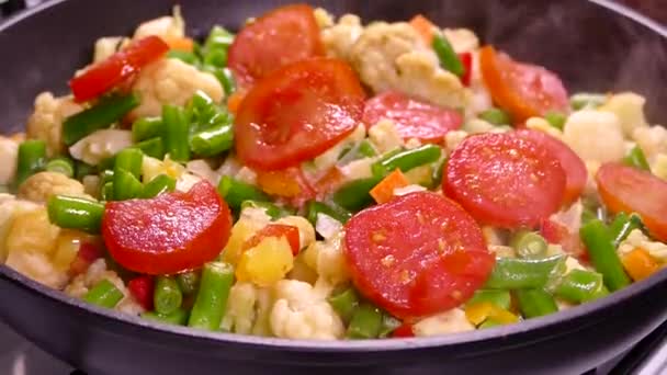 用冷冻切碎的蔬菜烹调蔬菜炖菜 西红柿 芦笋和卷心菜在锅里蒸着 — 图库视频影像