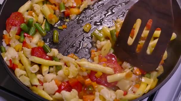 用冷冻切碎的蔬菜烹调蔬菜炖菜 西红柿 芦笋和卷心菜在锅里蒸着 用厨房的铲把菜搅拌一下 — 图库视频影像