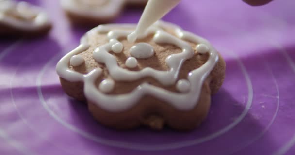 ジンジャーブレッドクッキーは 女性の手で白いアイシングで装飾されています 新年の休日のクッキー — ストック動画