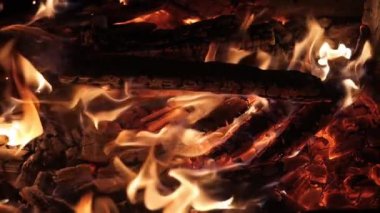 Siyah arka planda alevler ve kıvılcımlar. Büyük bir şenlik ateşi. Ateş ve tehlike. Şöminede odun yakmak. Romantik yangın. Geceleri yangın. Dikey video. doku.