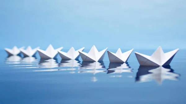 Uma Linha Origami Barco Papel Branco Superfície Água Fundo Azul — Fotografia de Stock